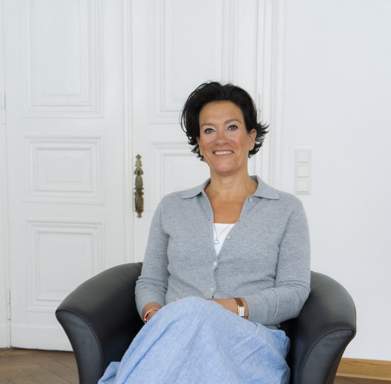Britta Hermann, systemische Beraterin aus Aachen, sitzt lächelnd in ihrem Beratungsraum